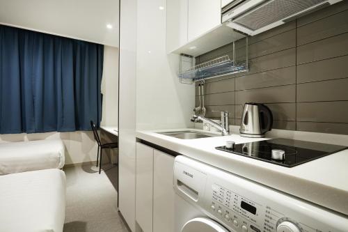 a small kitchen with a sink and a stove at Top Hotel & Residence in Seoul