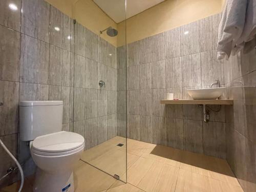 La salle de bains est pourvue de toilettes et d'un lavabo. dans l'établissement Seminyak Point Guest House, à Seminyak