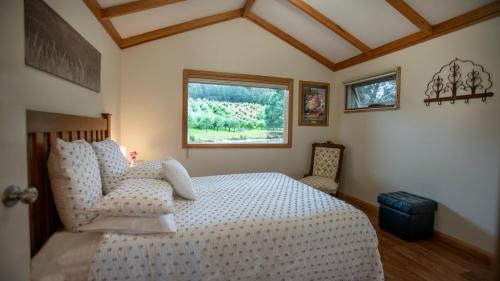 a bedroom with a white bed and a window at Wanderers Cottage in Woodbridge