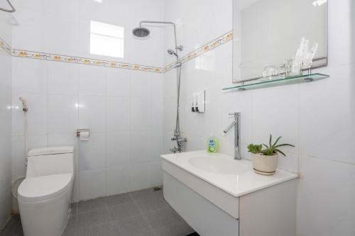 La salle de bains blanche est pourvue de toilettes et d'un lavabo. dans l'établissement VILLA CHERRY Vung Tau, à Vung Tau