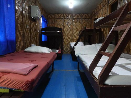 a room with two bunk beds and a blue floor at Enchanted River Rock Island Resort in Hinatuan