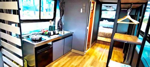 uma cozinha num trailer com um lavatório e uma secretária em Campod Resort @ Cameron Highlands em Cameron Highlands