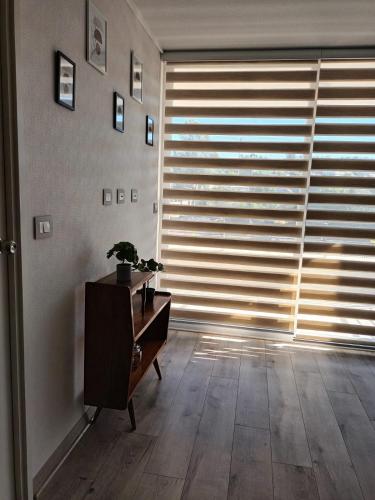 a living room with a large window with blinds at Grato y Bello departamento in Quilpué