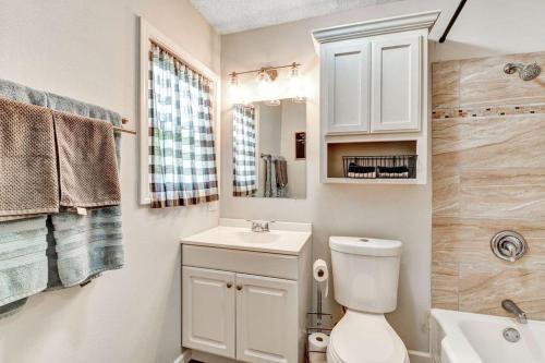 Baño blanco con aseo y lavamanos en Pecan Hill House, en Waco
