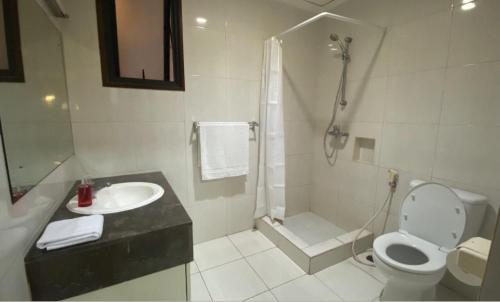 ein Bad mit einem WC, einer Dusche und einem Waschbecken in der Unterkunft Park Royale Apartments, Senayan, Jakarta in Jakarta