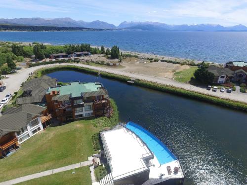 una vista aérea de una casa y un barco en el agua en Blue Aparts Dina Huapi Bariloche en Dina Huapi