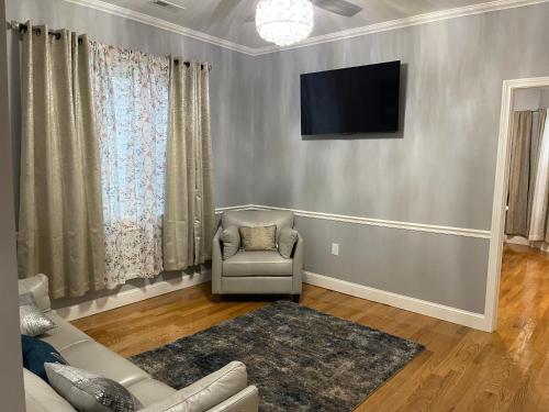 a living room with a couch and a television on a wall at Boston Luxury 3 bedroom Private Condo in Boston