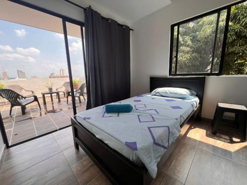 a bedroom with a bed and a balcony at Epifania Hostel in Cali