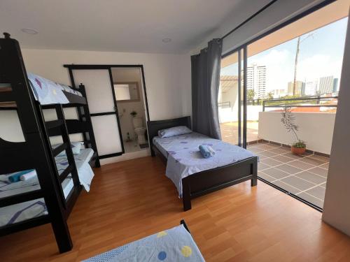 sypialnia z łóżkiem piętrowym i balkonem w obiekcie Epifania Hostel w mieście Cali