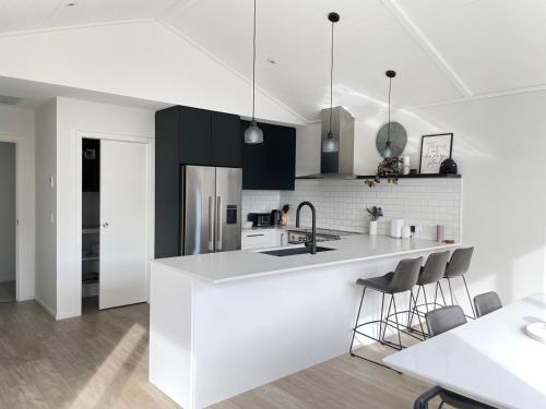 a white kitchen with a sink and a counter at Queenstown Mountain Getaway in Queenstown