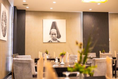 a restaurant with tables and chairs and a picture of a man at LAOTEL VIENTIANE in Vientiane