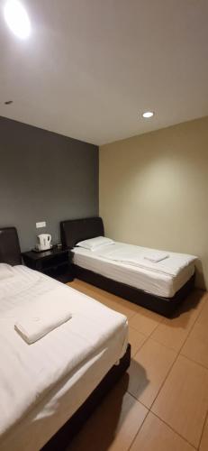 a room with two beds in a room with at Tas Sakura Budget Hotel in Kampong Baharu