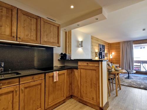 une cuisine avec des placards en bois et une salle à manger dans l'établissement Luxueux Appartement 2 Chambres au Cœur de Courchevel 1850, Balcon, Parking et Services Inclus - FR-1-613A-7, à Courchevel