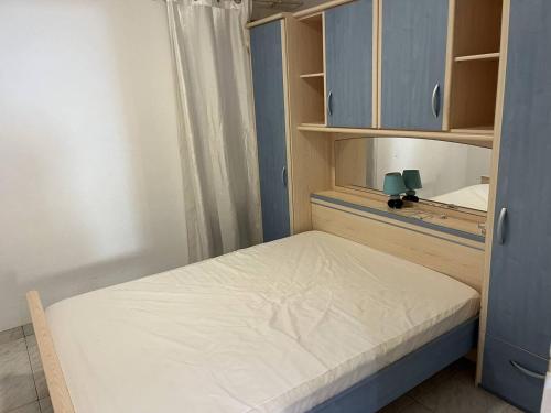 - une petite chambre avec un lit et des armoires bleues dans l'établissement Appartement Climatisé avec Parking à 500m de la Plage pour Vacances Familiales - FR-1-749-30, au Cap d'Agde