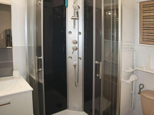 une douche avec une porte vitrée dans une salle de bain dans l'établissement Studio rénové, skis aux pieds, centre station, 4 pers - FR-1-322-540, aux Orres