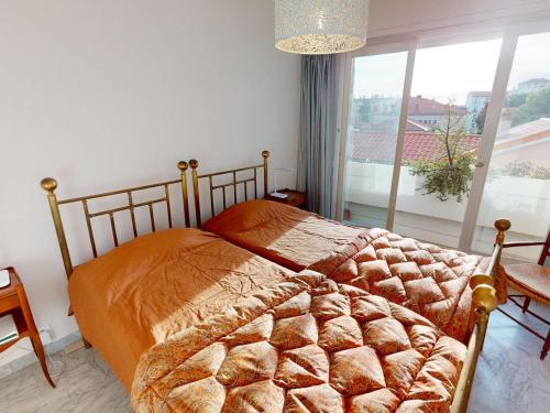 une chambre avec un lit et une grande fenêtre dans l'établissement Agréable 3P à Menton avec Balcon, Parking Privé et Proche Plages - FR-1-196-347, à Menton