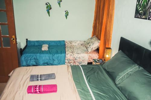 Un dormitorio con una cama con una bolsa rosa y verde. en Suítes Cocaia en Ilhabela