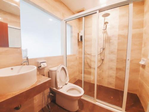 a bathroom with a shower and a toilet and a sink at Suan Sai Yok Resort in Sai Yok