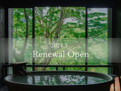 箱根町にある和の宿 華ごころ - 2024年3月リニューアルオープンの窓の前にバスタブが備わります。