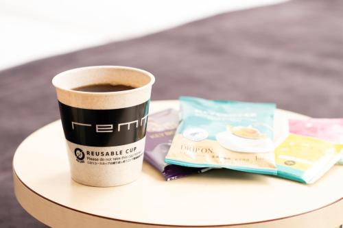 a cup of coffee and a book on a table at remm Roppongi in Tokyo