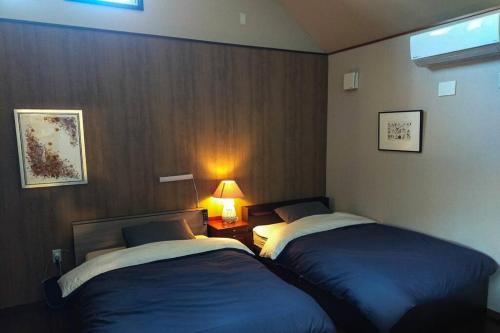 Postel nebo postele na pokoji v ubytování 伊豆高原 桜並木通りに面したコテージJiro's