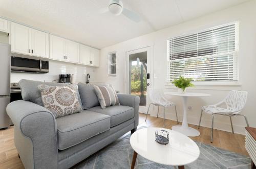 a living room with a couch and a table at Be A Nomad - Beachside Apartments in Jacksonville Beach