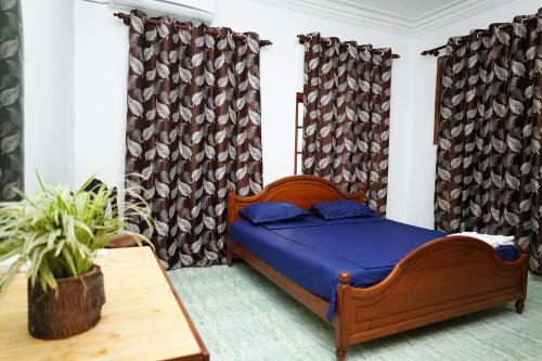 a bedroom with a bed and a table and curtains at The Anam Hostel in Colombo