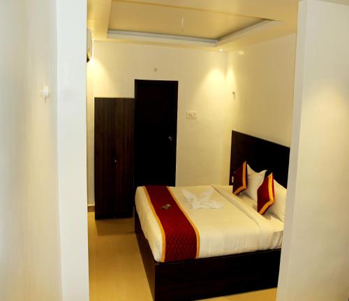 een slaapkamer met een bed in een kamer bij G R B Hotels Aishwarya Grand in Pondicherry