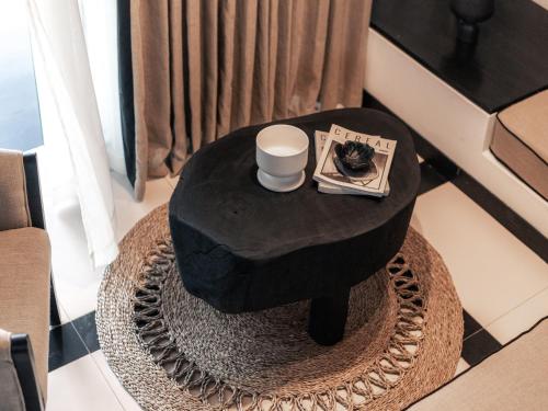 a black table with a cup of coffee and a newspaper at Sun Siyam Pasikudah in Pasikuda