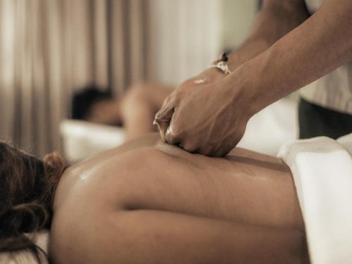 a woman getting a back massage from a therapist at Sun Siyam Pasikudah in Pasikuda