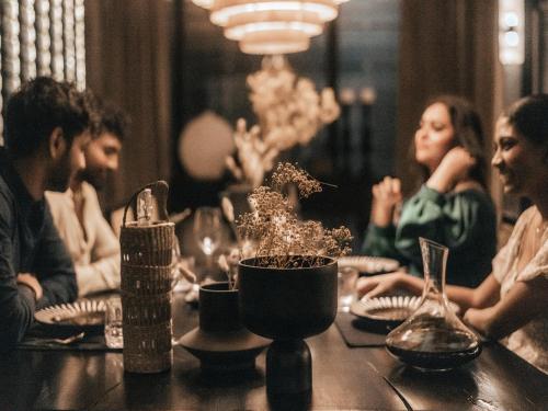 a group of people sitting at a table in a restaurant at Sun Siyam Pasikudah in Pasikuda