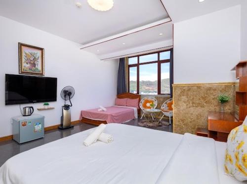1 dormitorio con 1 cama blanca y sala de estar en KHÁCH SẠN SƠN THỊNH 23D THÙY VÂN, en Vung Tau