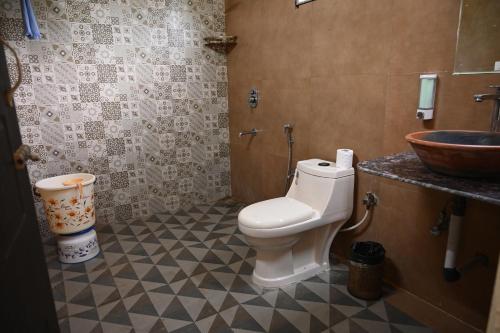 a bathroom with a toilet and a sink at Gramya Resort in Alwar
