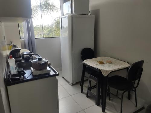 a small kitchen with a table and a refrigerator at AP Completo NOVO, com Ar condicionado, internet rápida e Garagem privativa in Paranaguá