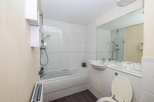 La salle de bains blanche est pourvue de toilettes et d'un lavabo. dans l'établissement Pristine Relocation Pamers Green, à Londres