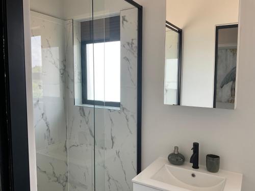a bathroom with a sink and a glass shower at The Blyde Stylish Homes in Pretoria