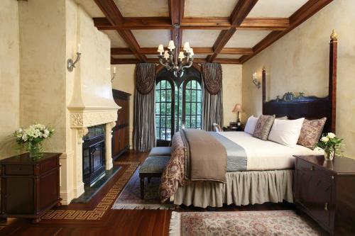 a bedroom with a large bed and a fireplace at Ledson Hotel & Zina Lounge in Sonoma