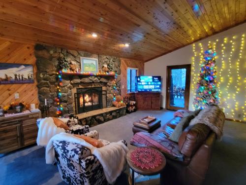 a living room with a fireplace and a christmas tree at Four Seasons Getaway-Private Hot Spa with Pine Tree Views-Walk to Village and Pineknot Trailhead-Plus King Bed! in Big Bear Lake