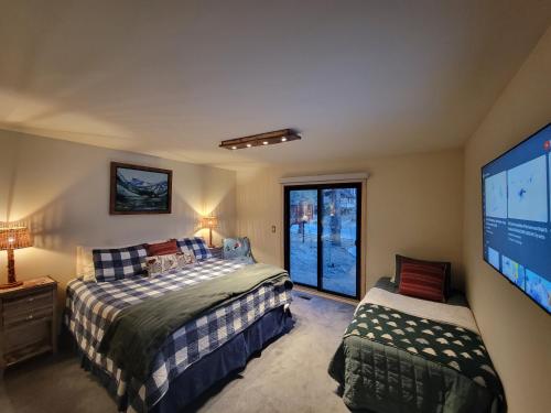 a bedroom with two beds and a flat screen tv at Four Seasons Getaway-with Hot Tub, Next to Village and Hiking Trailhead in Big Bear Lake