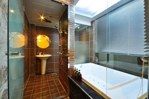 a bathroom with a tub and a sink at Boutique Hotel Aria Nampo in Busan