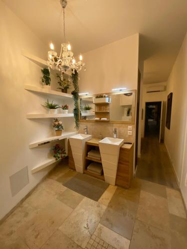 a bathroom with two sinks and a chandelier at Loft Spa Reims-fr 250m2 privatifs, piscine intérieure chauffée, spa et parking in Reims