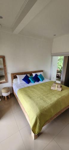 1 dormitorio con 1 cama grande con almohadas azules en Yobi House, en Ubud