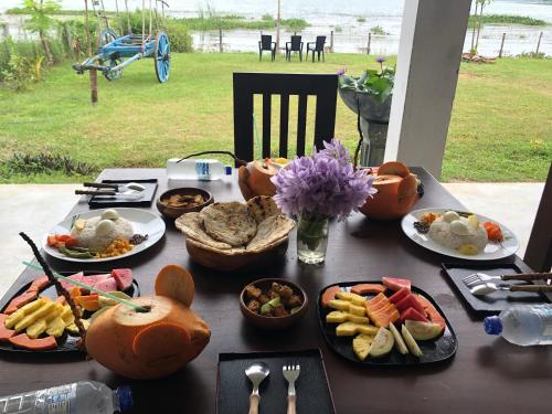 uma mesa com diferentes pratos de comida em Lapwing Lake Villa em Tissamaharama