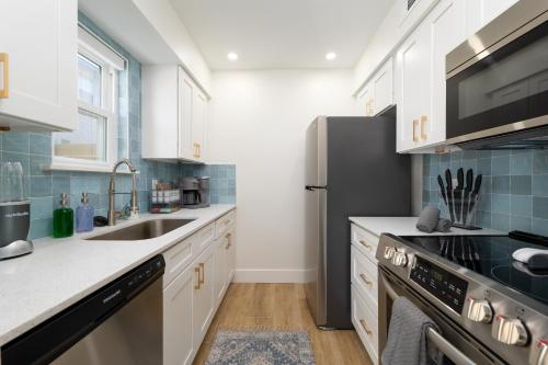 a kitchen with white cabinets and a black refrigerator at Be A Nomad 2 br Close to the Beach in Jacksonville Beach