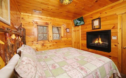 a bedroom with a fireplace in a log cabin at First Flight in Sevierville