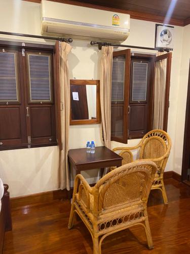 a room with a table and two chairs and a table at somvang khily guesthouse 宋旺吉利 酒店 in Luang Prabang