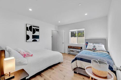 a white bedroom with a bed and a window at Stellar NoHo Art home with new design in Los Angeles