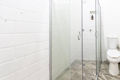een badkamer met een toilet en een glazen douche bij Casa Marina: Habitación Chiapas in Acámbaro