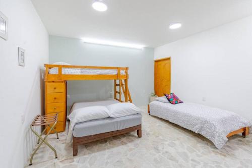 een slaapkamer met een stapelbed en 2 aparte bedden bij Casa Marina: Habitación Chiapas in Acámbaro