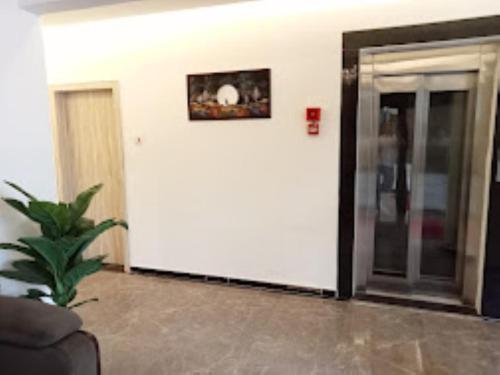 ein Wohnzimmer mit einer Tür und einer Pflanze in der Unterkunft Hotel Grand Residency , Kolegaon in Dive